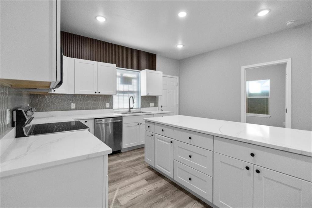 3512 Hamilton Avenue Dallas, TX 75210 - Photo 9 of 23 Kitchen featuring white cabinetry, stainless steel appliances, light stone counters, light wood-style floors, and recessed lighting