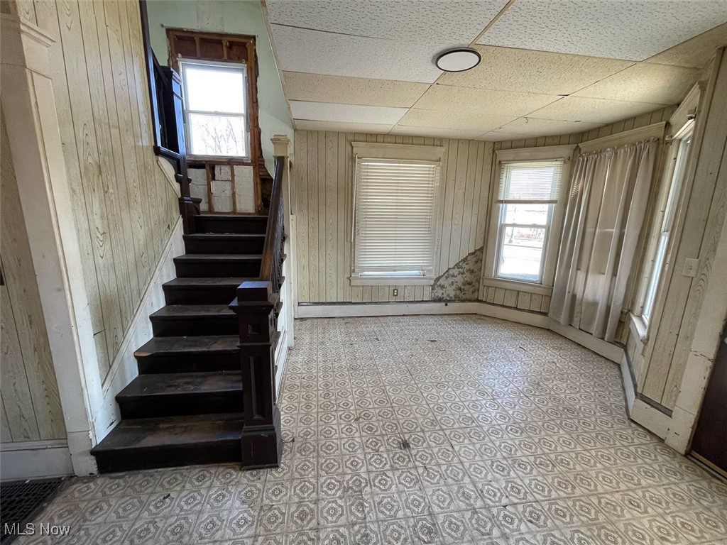 2703 Mahoning Road Northeast Canton, OH 44705 - Photo 13 of 21 Staircase with a wealth of natural light, wooden walls, and a paneled ceiling