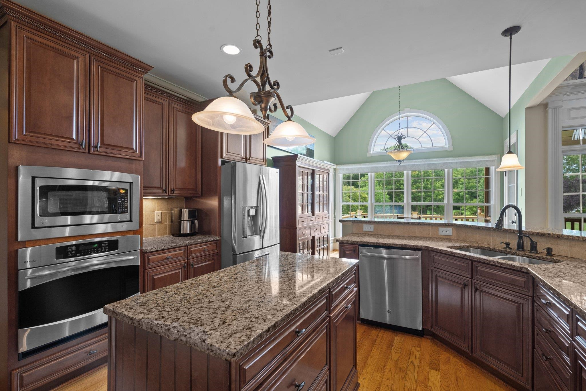 5805 Clovis Ridge Drive Wake Forest, NC 27587 - Photo 12 of 64 a kitchen with stainless steel appliances granite countertop a sink a stove and a wooden cabinets
