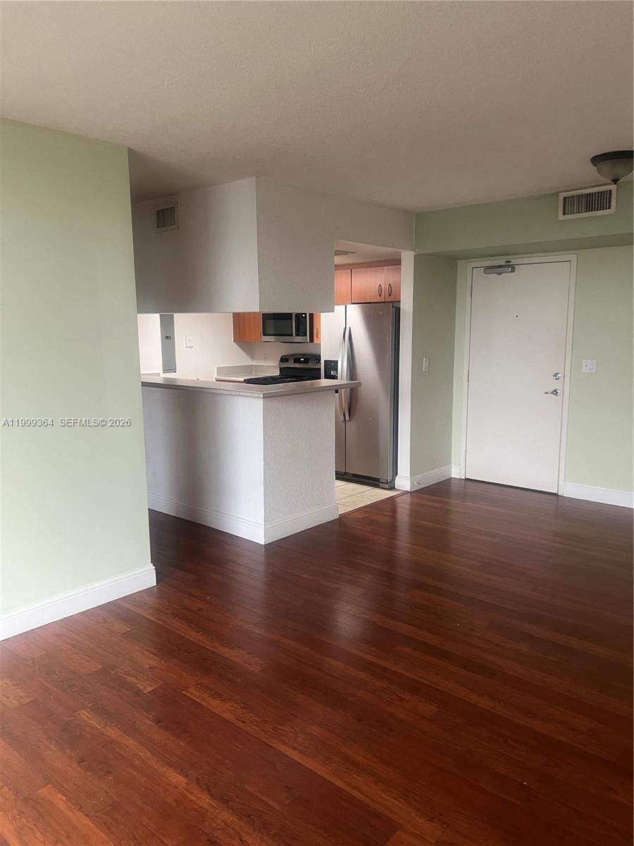816 Northwest 11th Street, Unit 1002 Miami, FL 33136 - Photo 1 of 19 a kitchen with granite countertop wooden floors and stainless steel appliances