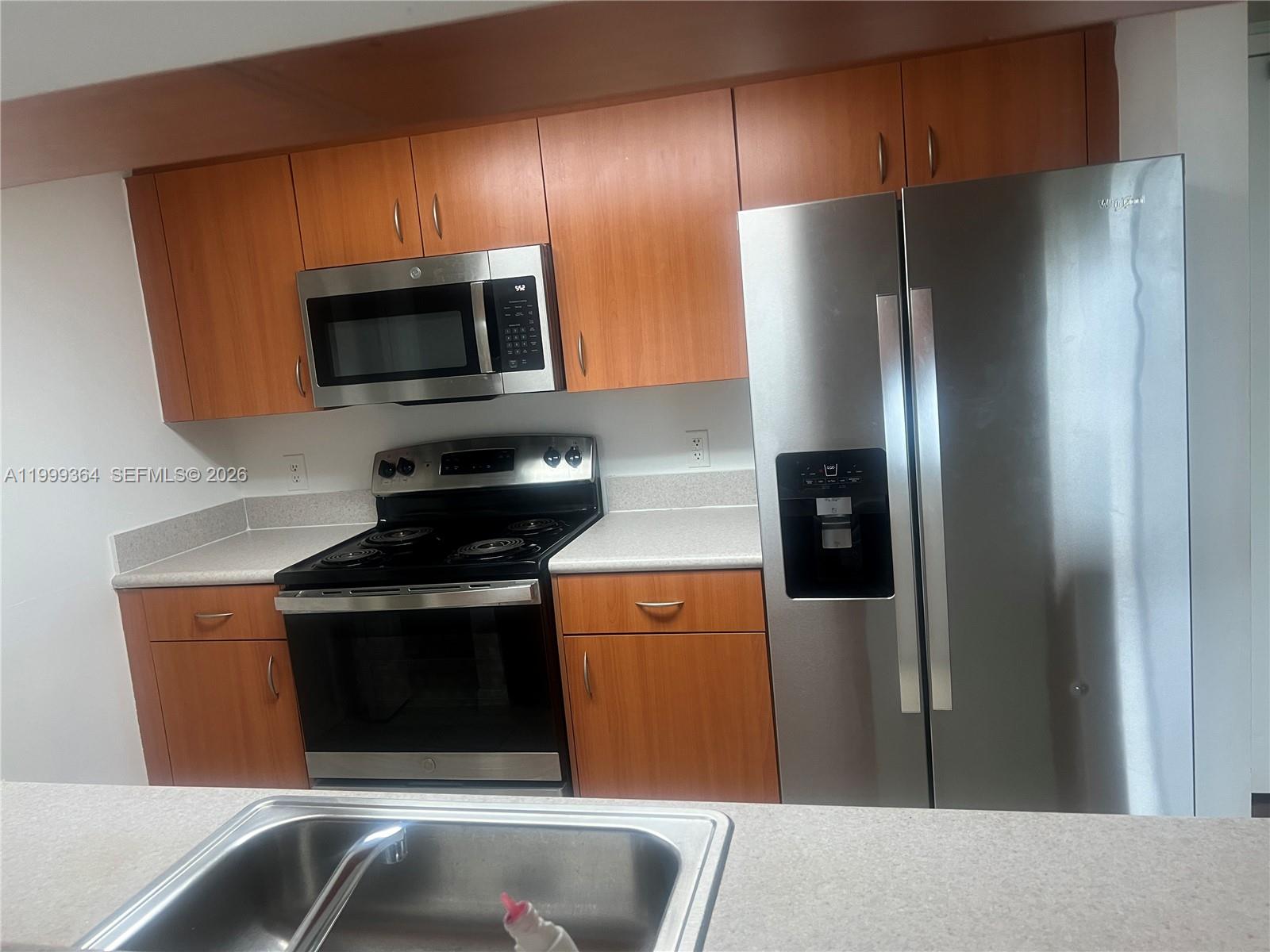 816 Northwest 11th Street, Unit 1002 Miami, FL 33136 - Photo 4 of 19 a kitchen with stainless steel appliances granite countertop a refrigerator stove and microwave