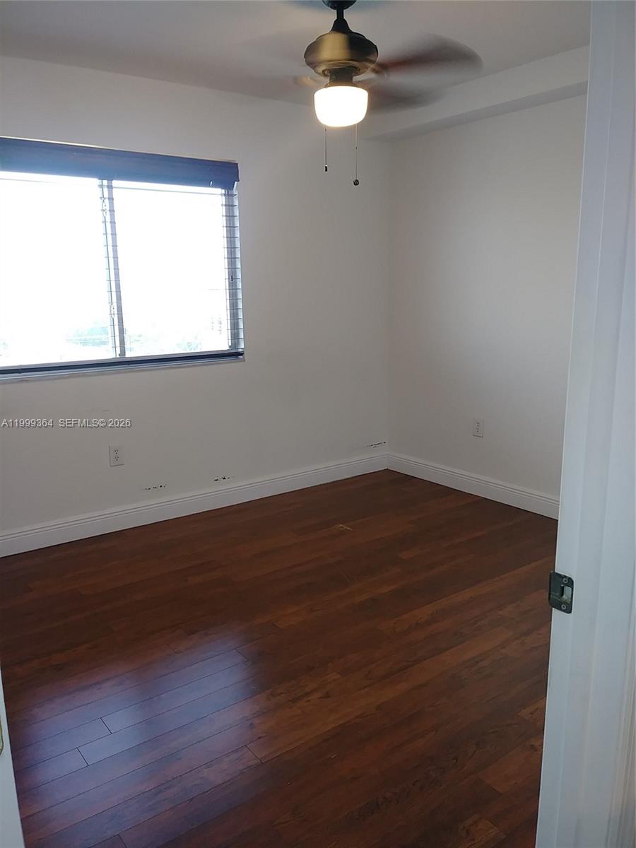 816 Northwest 11th Street, Unit 1002 Miami, FL 33136 - Photo 10 of 19 an empty room with wooden floor and windows