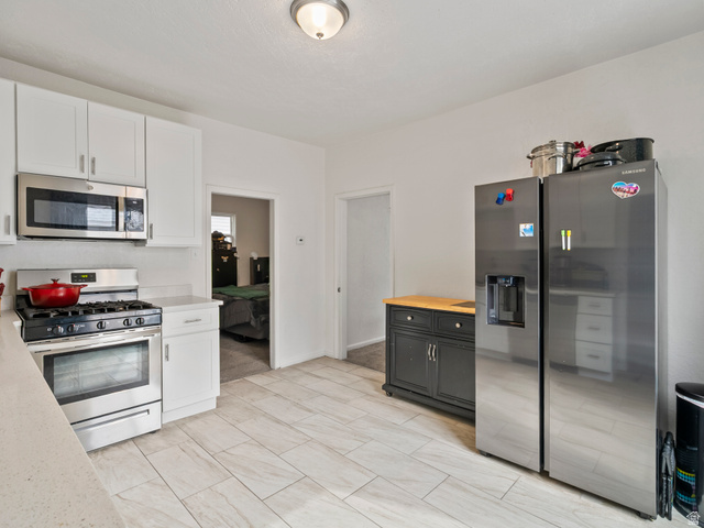 510 Canyon Road Ogden, UT 84404 - Photo 4 of 30 Kitchen with stainless steel appliances, wooden counters, and white cabinetry