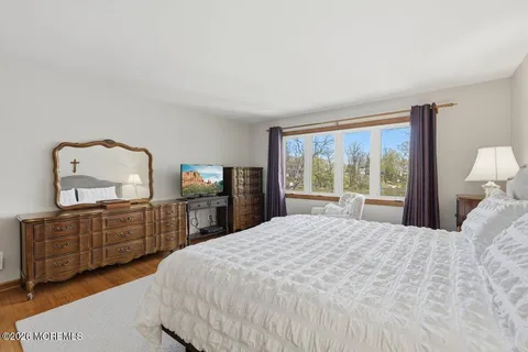 a bedroom with a bed window and dresser