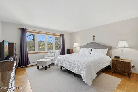 a bedroom with a bed chairs and a flat screen tv