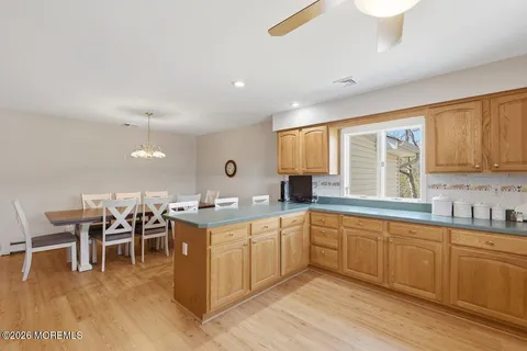 a open kitchen with lots of chairs a sink dishwasher a dining table and chairs with wooden floor