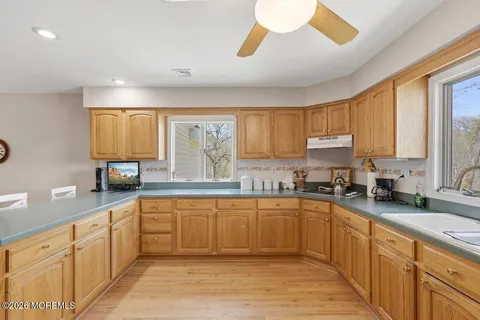 a large kitchen with stainless steel appliances granite countertop a sink counter space cabinets and a large window