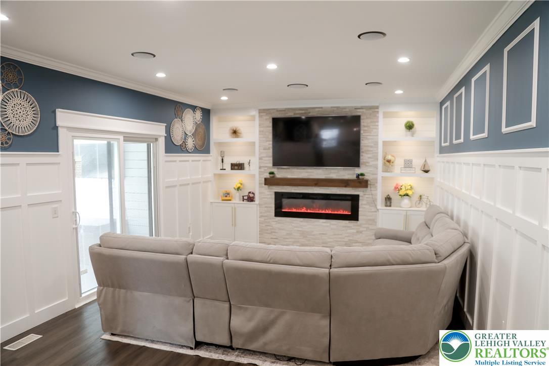 1412 Stanford Road Bethlehem, PA 18018 - Photo 24 of 58 A refined living area boasts built-in shelving, a modern fireplace, and rich wood flooring.