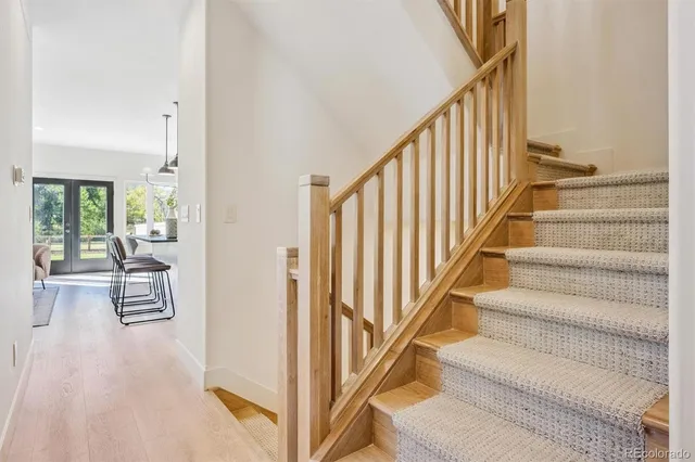 a view of staircase with lots of frames on wall and windows