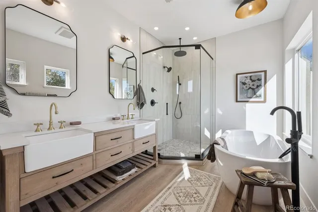 a spacious bathroom with double vanity sink a mirror a glass door and shower