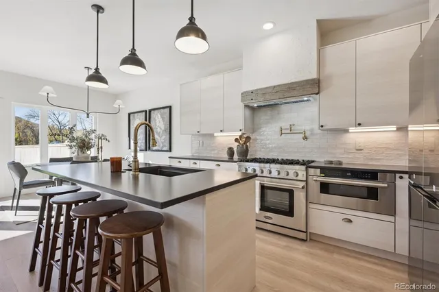 a kitchen with stainless steel appliances granite countertop a stove a sink and a refrigerator