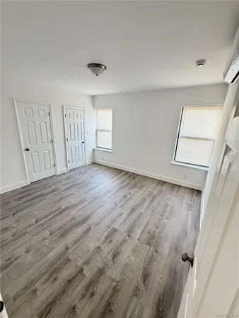 an empty room with wooden floor and window