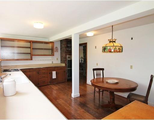 16 Foster Road Lexington, MA 02421 - Photo 11 of 21 a kitchen with stainless steel appliances granite countertop a sink dishwasher a stove a refrigerator with a dining table and chairs