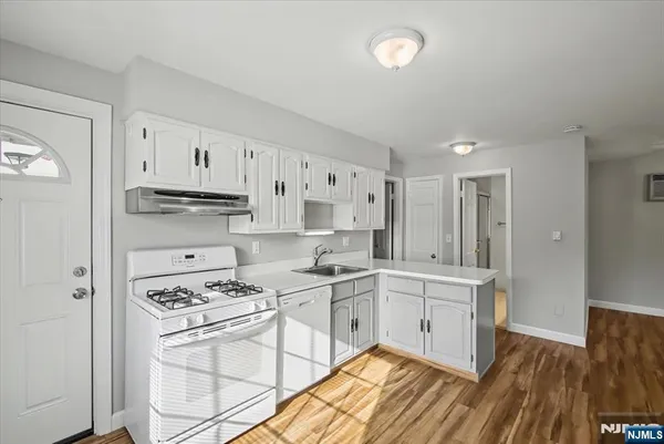 a kitchen with white cabinets and white appliances