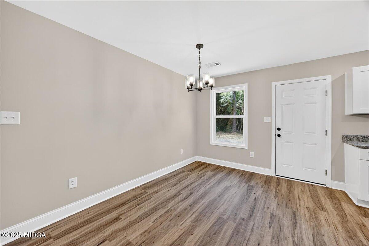 315 Lee Street Perry, GA 31069 - Photo 11 of 26 wooden floor in an empty room with a window