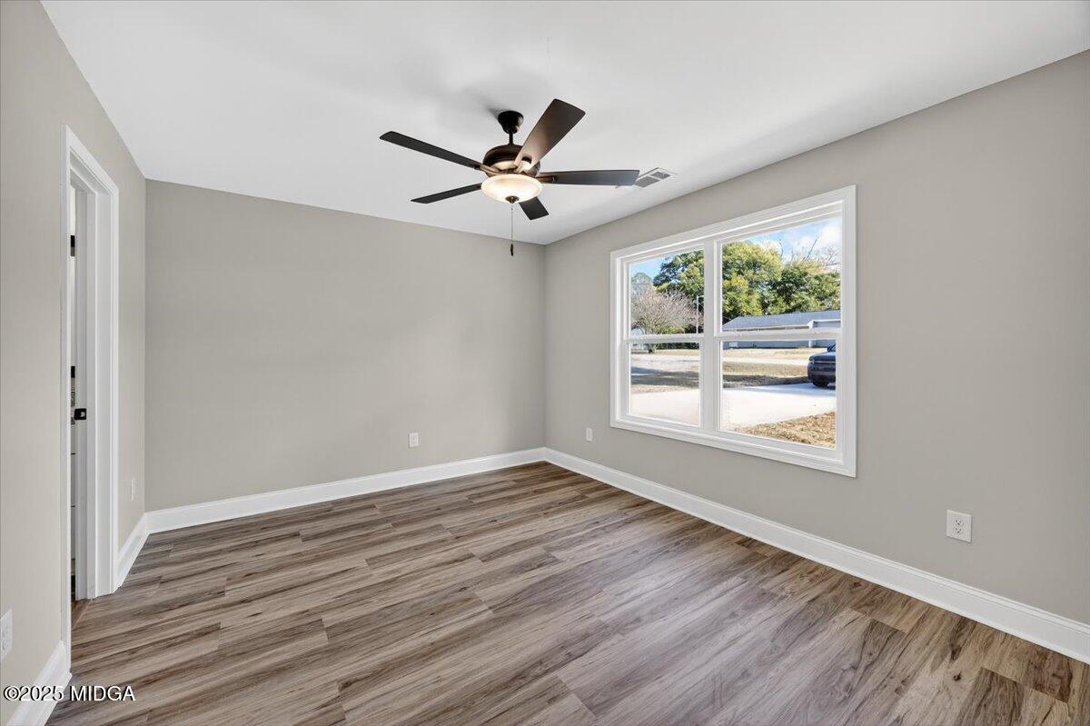 315 Lee Street Perry, GA 31069 - Photo 13 of 26 a view of an empty room with wooden floor and a window