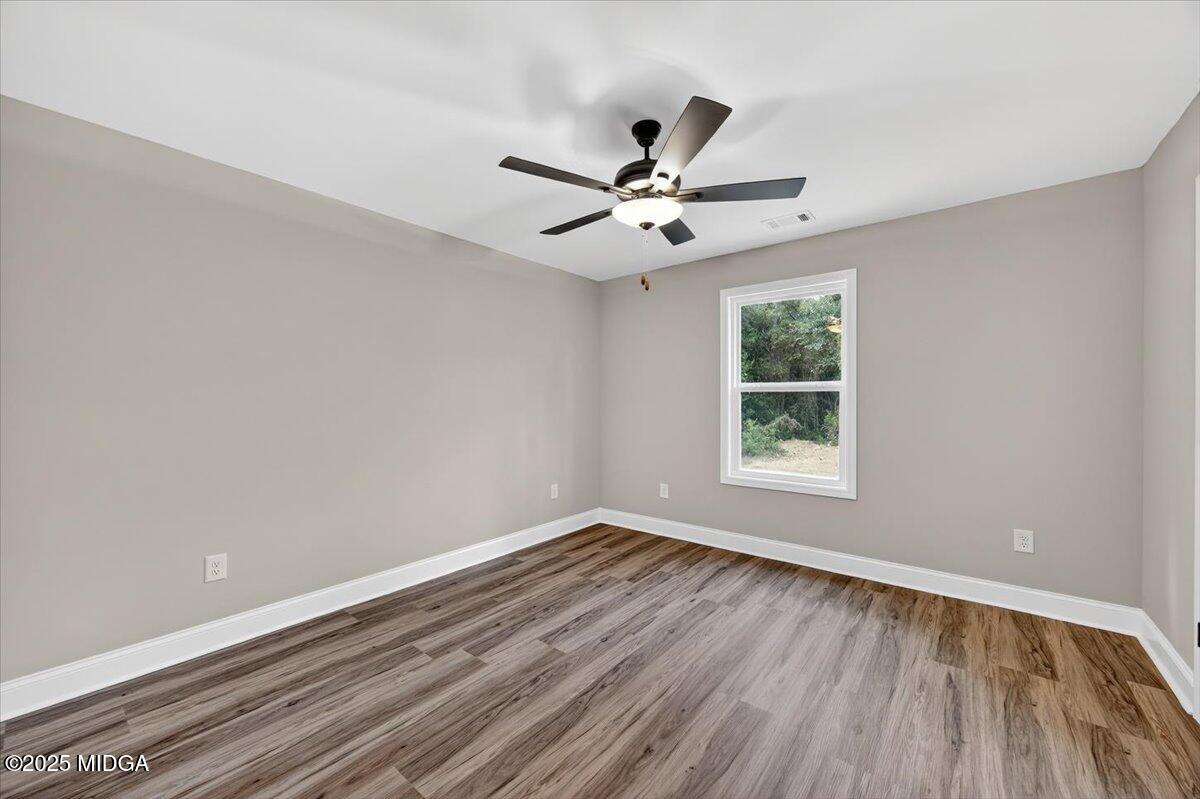 315 Lee Street Perry, GA 31069 - Photo 17 of 26 wooden floor in an empty room with a window