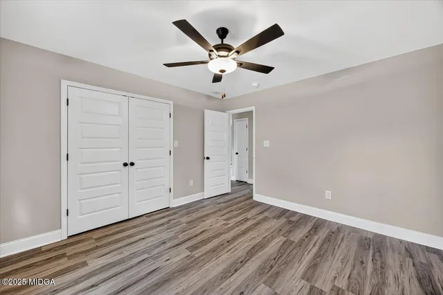 an empty room with closet and fan