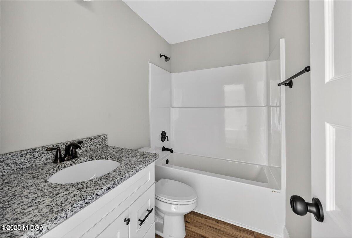 315 Lee Street Perry, GA 31069 - Photo 19 of 26 a bathroom with a granite countertop sink toilet and shower