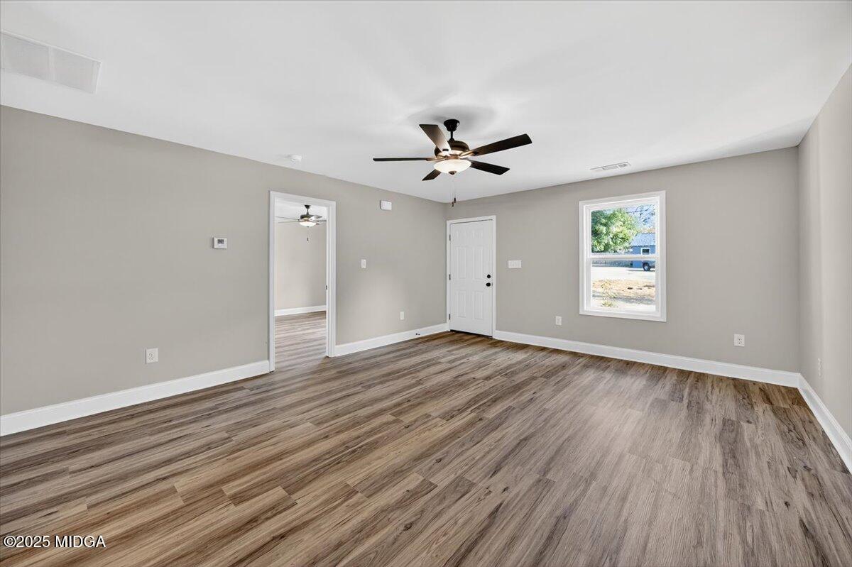 315 Lee Street Perry, GA 31069 - Photo 4 of 26 a view of an empty room with window and wooden floor