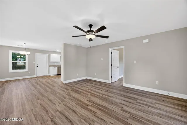 an empty room with fan and windows
