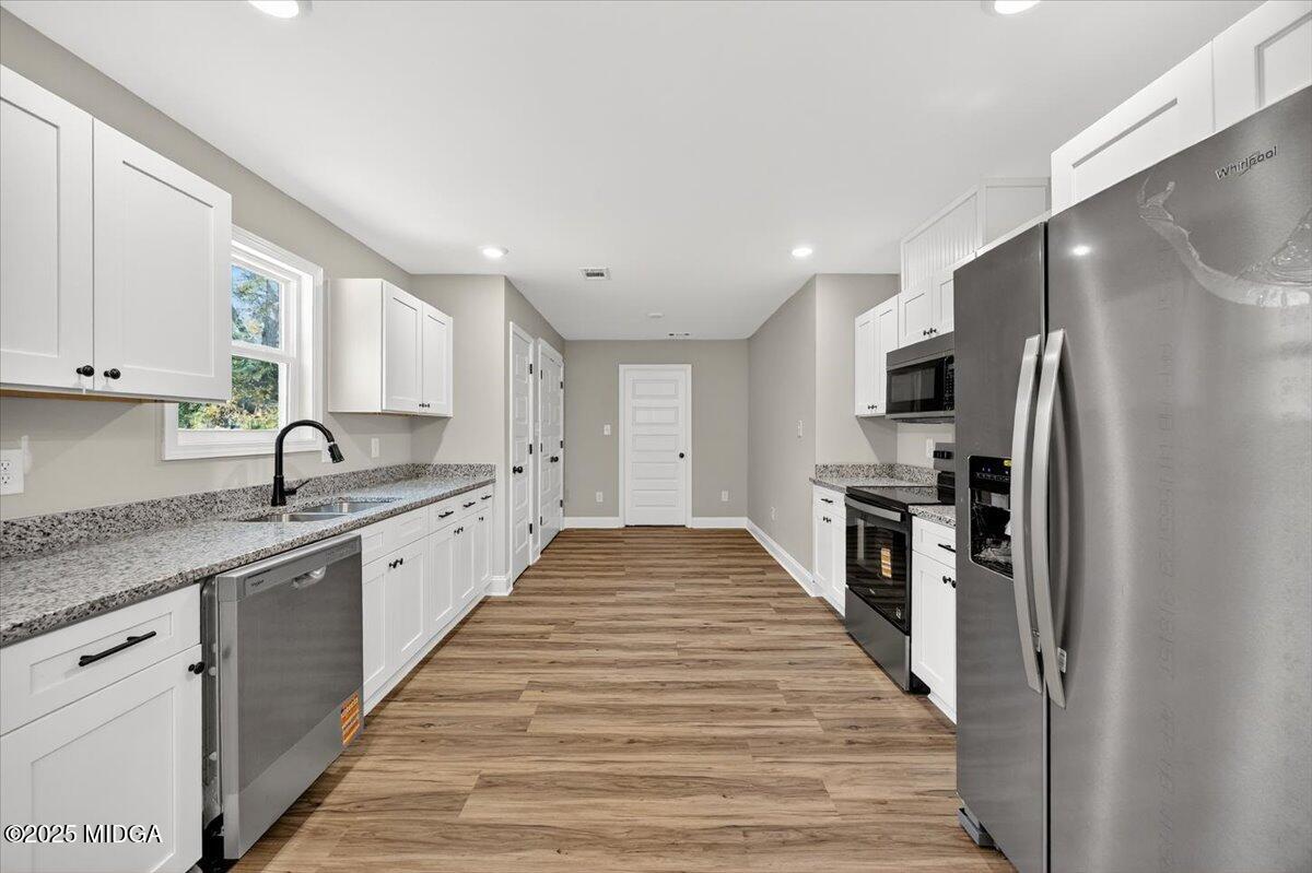 315 Lee Street Perry, GA 31069 - Photo 7 of 26 a large kitchen with stainless steel appliances granite countertop a refrigerator and a stove top oven