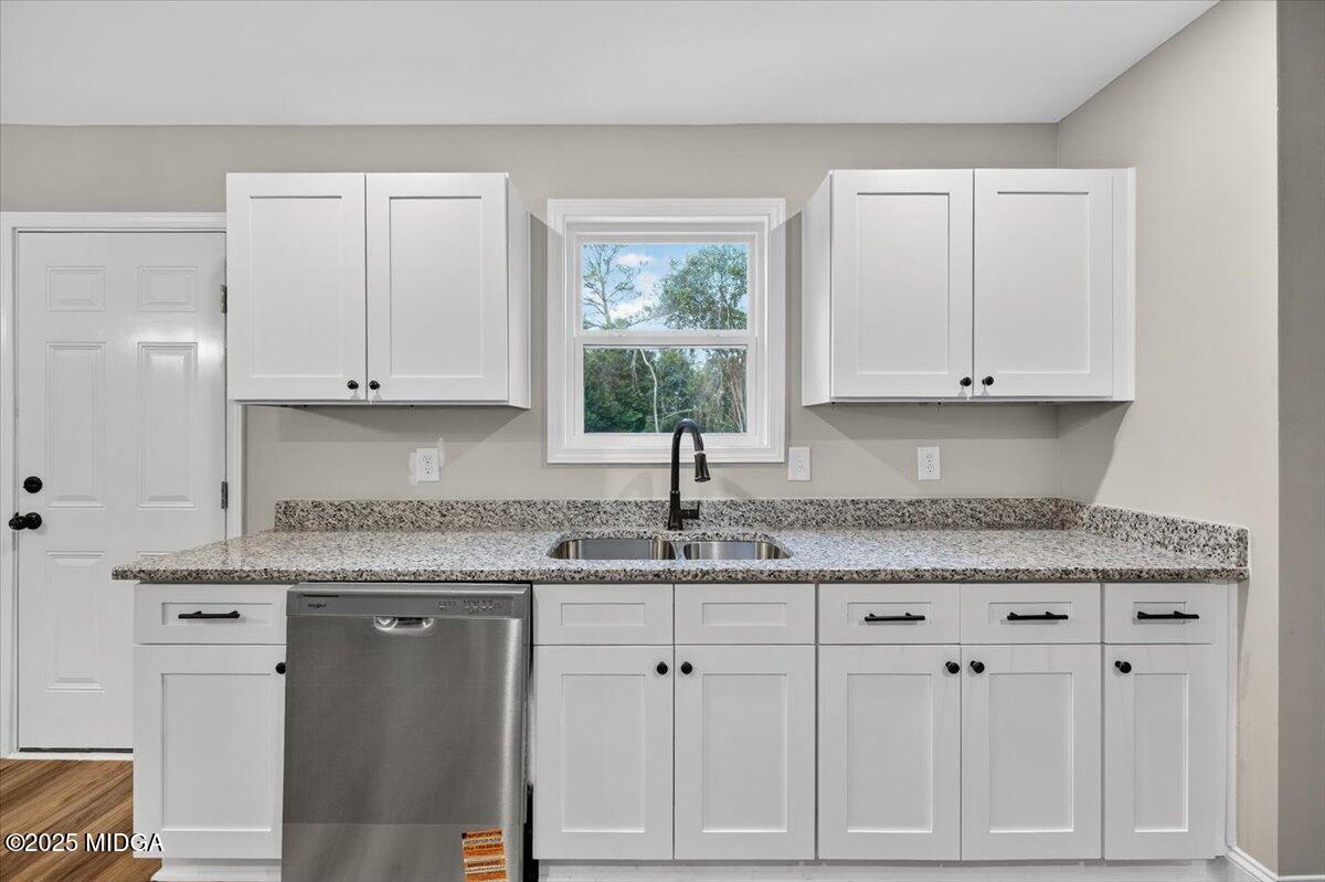 315 Lee Street Perry, GA 31069 - Photo 9 of 26 a kitchen with granite countertop white cabinets and a sink