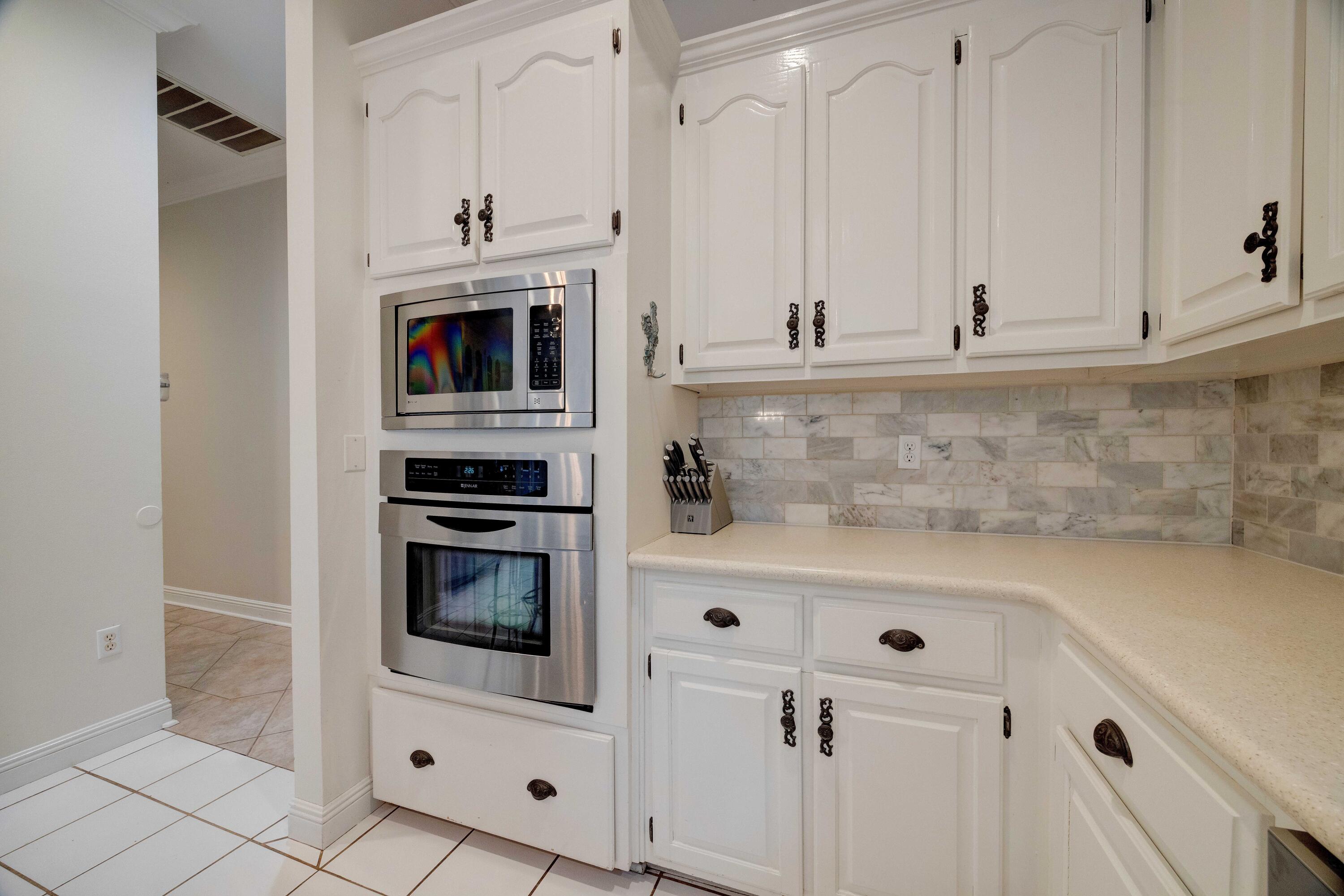 1111 Tallokas Road Crestview, FL 32536 - Photo 13 of 56 a kitchen with white cabinets and stainless steel appliances