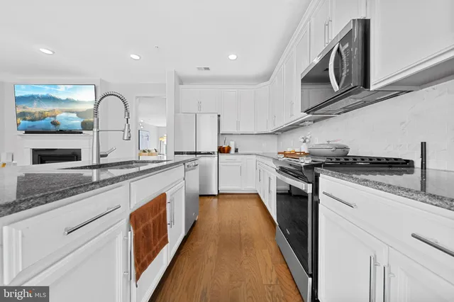 a kitchen with appliances a sink and cabinets