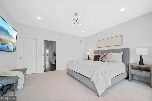 a bedroom with a large bed and a large mirror