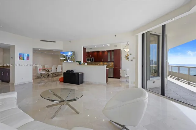 a kitchen with a refrigerator and a view of living room