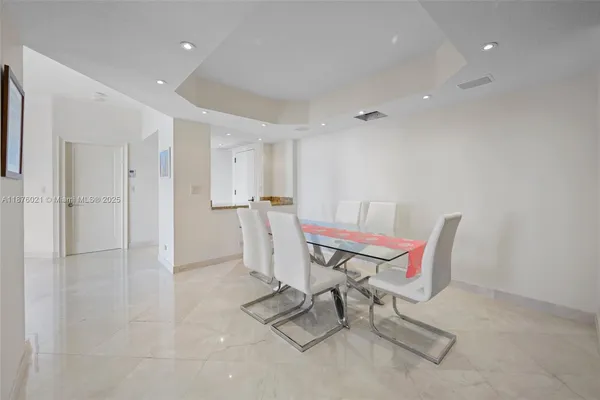 a living room with furniture and a dining table with wooden floor