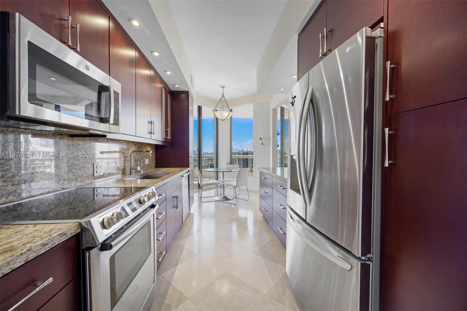 20191 East Country Club Drive, Unit TS8 Aventura, FL 33180 - Photo 7 of 27 a kitchen with stainless steel appliances granite countertop a refrigerator a stove and a sink with wooden cabinets