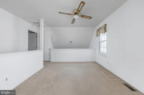 a view of empty room with ceiling fan