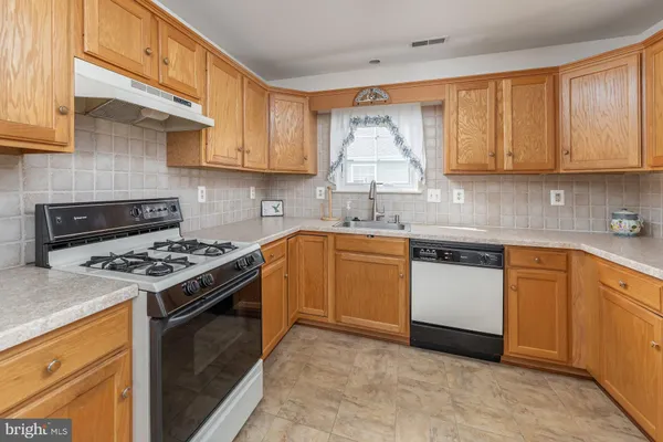 a kitchen with a sink stove and cabinets