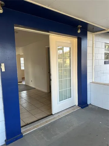 a view of an empty room with glass door and a window