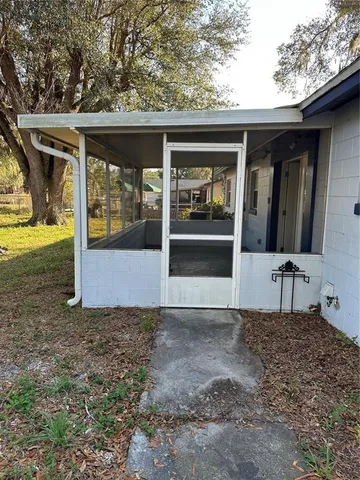 a view of backyard with large trees and wooden fence