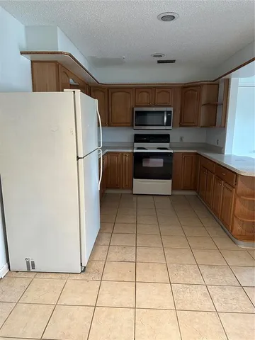 a kitchen with stainless steel appliances a refrigerator sink and cabinets