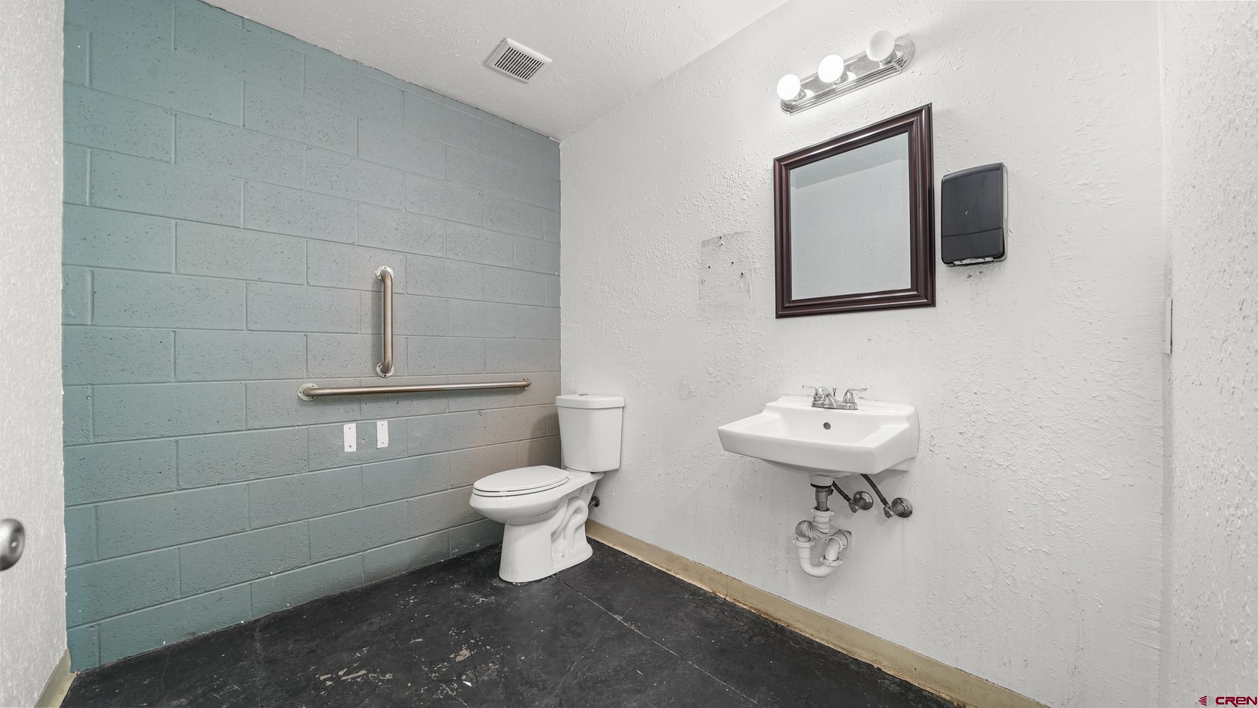 743 Highway 6&50 Fruita, CO 81521 - Photo 12 of 26 a bathroom with a toilet a sink a mirror and vanity