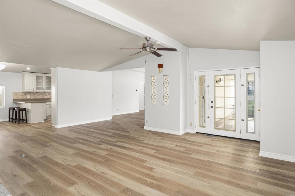 909 Richland Road, Unit 84 San Marcos, CA 92069 - Photo 11 of 35 a view of a kitchen with an empty room and wooden floor