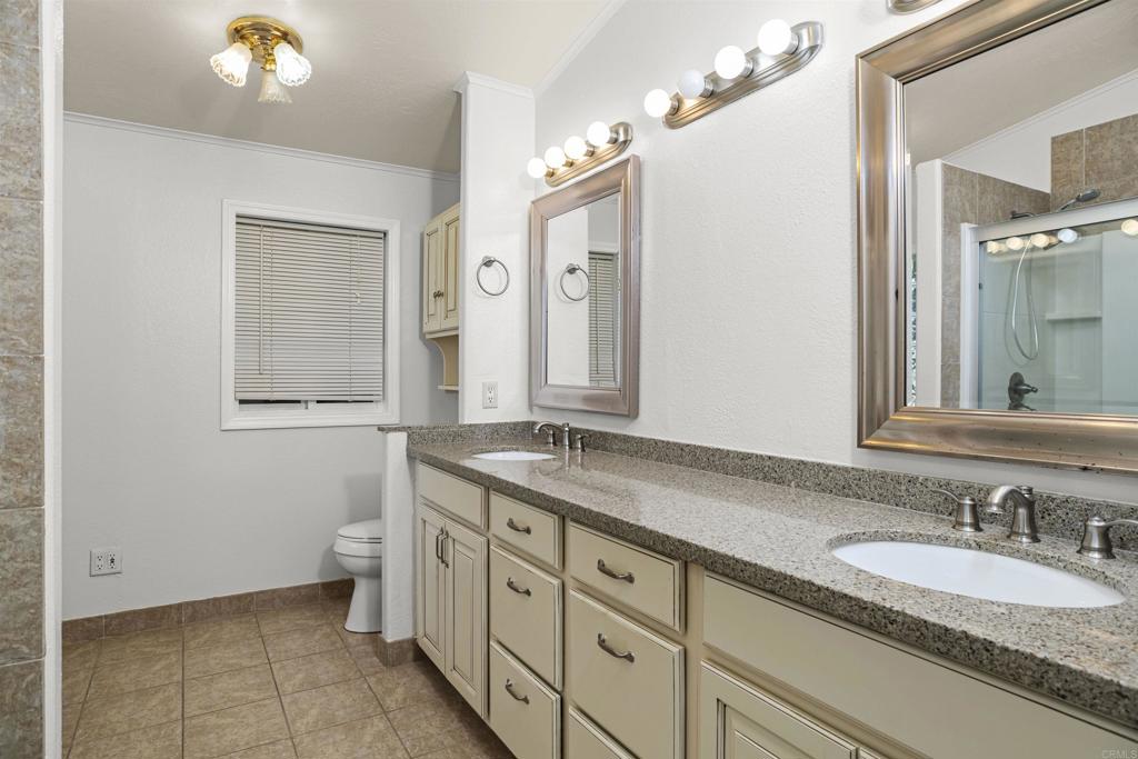 909 Richland Road, Unit 84 San Marcos, CA 92069 - Photo 27 of 35 a bathroom with a granite countertop sink mirror and a