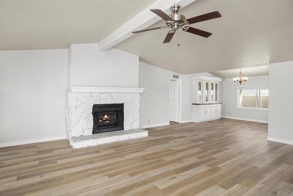 909 Richland Road, Unit 84 San Marcos, CA 92069 - Photo 8 of 35 a view of a livingroom with a fireplace a ceiling fan and wooden floor