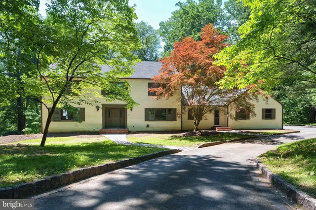 a front view of a house with a yard and trees