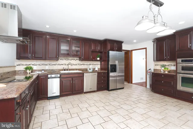 a kitchen with stainless steel appliances granite countertop a refrigerator a stove top oven a sink and dishwasher
