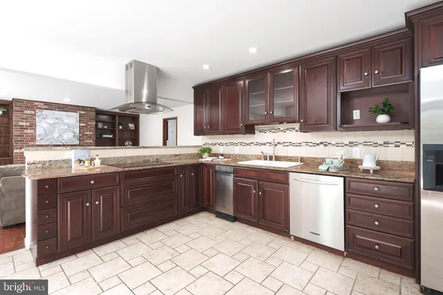 a kitchen with stainless steel appliances granite countertop wooden cabinets and a sink