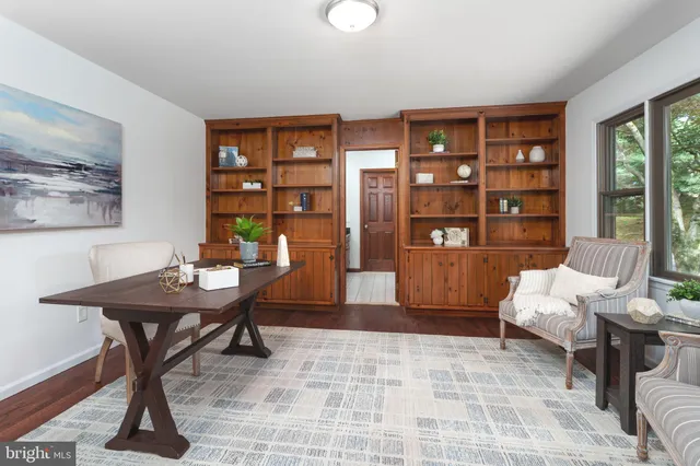 a view of a workspace with furniture and a bookshelf