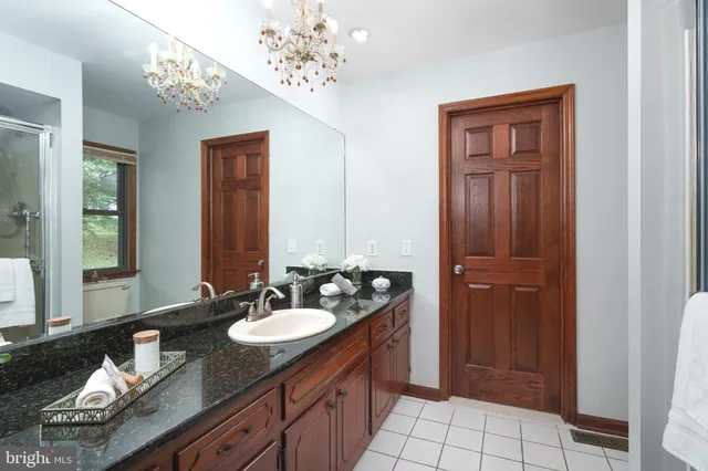 a spacious bathroom with a granite countertop sink and a mirror