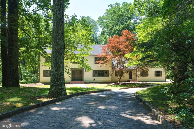 a front view of a house with a yard and trees