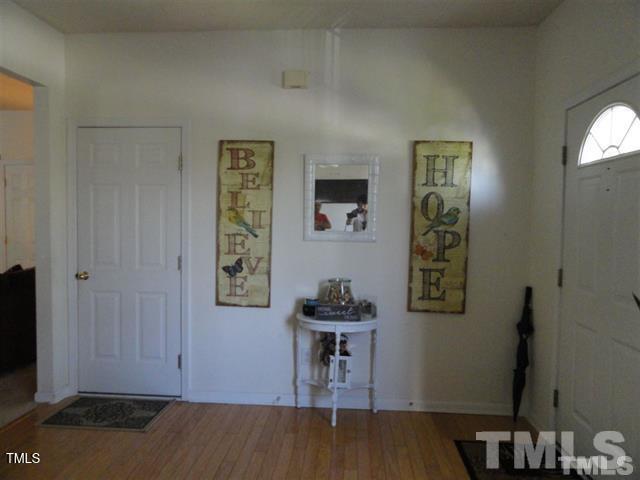 308 Durston Loop Morrisville, NC 27560 - Photo 7 of 13 a view of a hallway with wooden floor and dining room