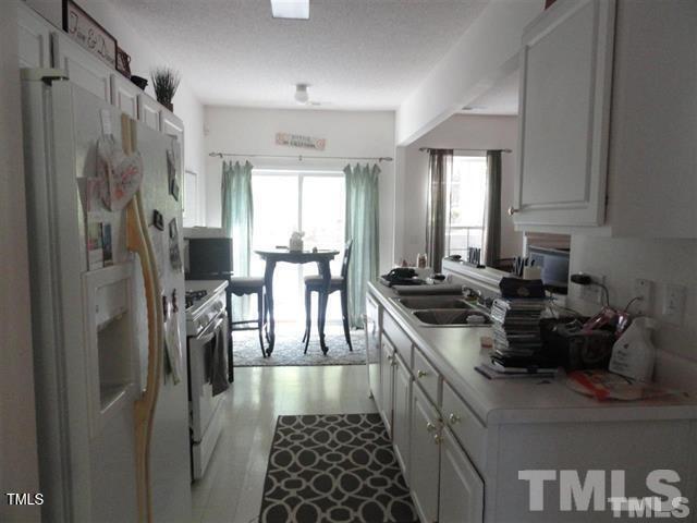 308 Durston Loop Morrisville, NC 27560 - Photo 8 of 13 a kitchen with stainless steel appliances granite countertop a sink stove and refrigerator